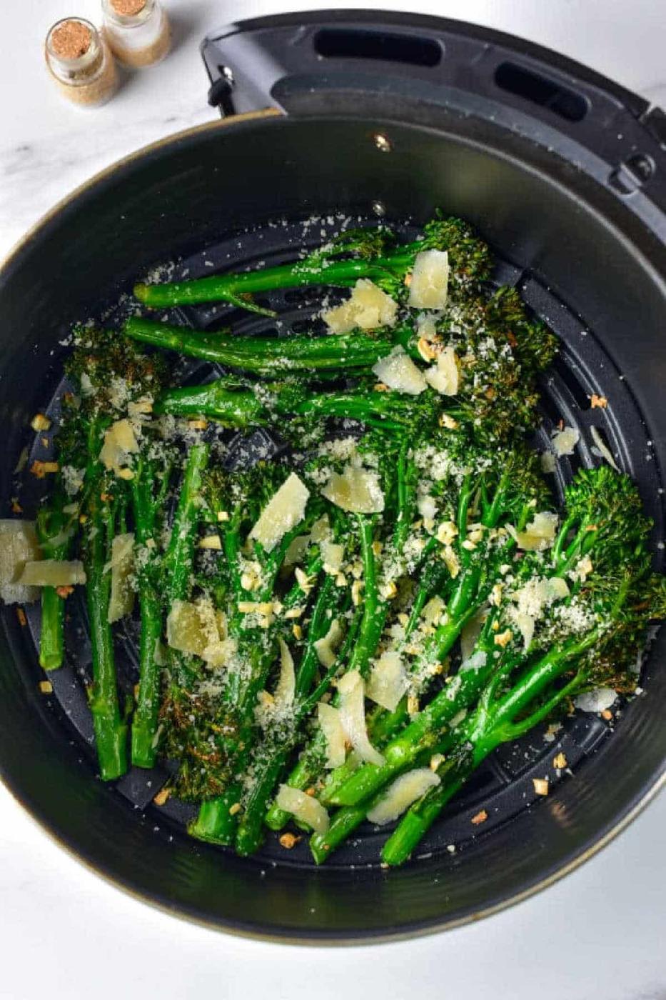 Air Fryer Broccolini topped with parmesan cheese and garlic, crisped to perfection in the air fryer basket.