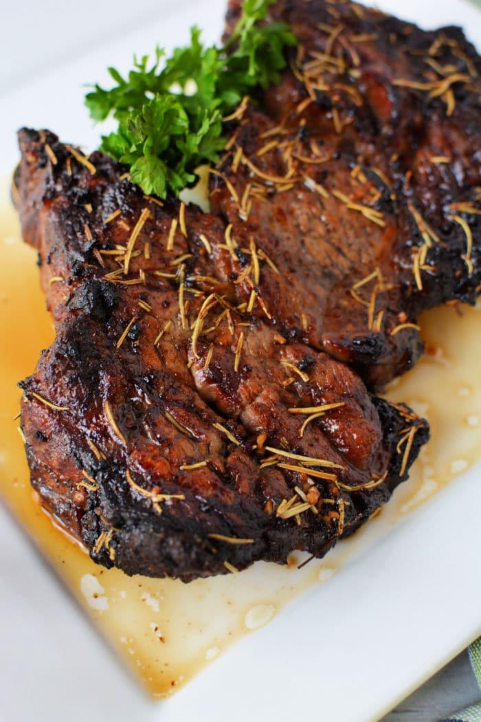 air fried chuck roast with rosemary and garnish sit elegantly on a white plate, reminiscent of an air fryer chuck roast cooked to perfection.
