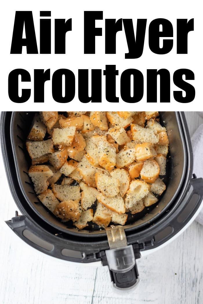 A crisp air fryer basket brimming with golden, seasoned croutons sits on a pristine white background. Text elegantly announces: Air Fryer Croutons.