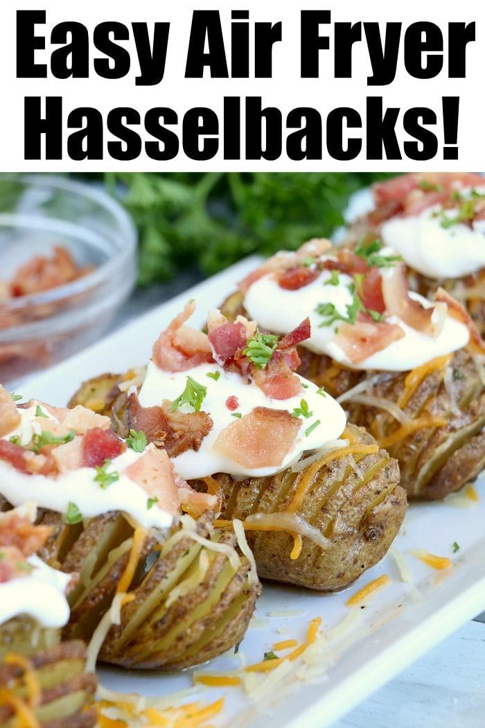 Crispy air fryer hasselback potatoes topped with sour cream, crispy bacon, and fresh herbs grace a white plate.