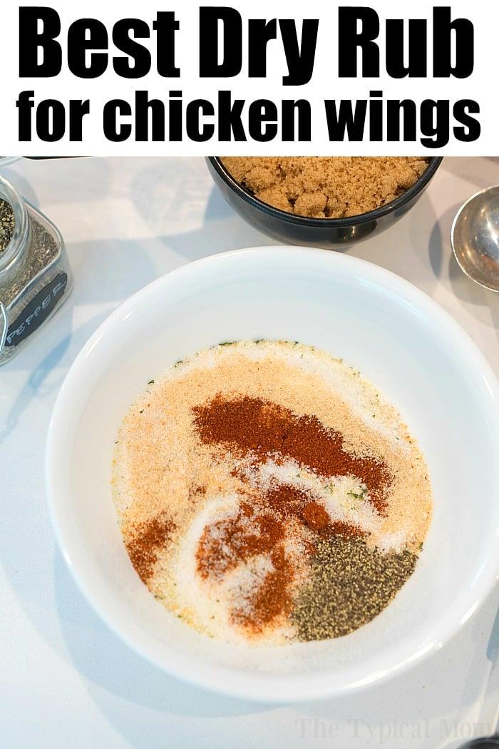 A white bowl brimming with spices for a dry rub, including brown sugar, paprika, and black pepper. Nearby sit a jar and bowl with similar ingredients. The text at the top reads, "Best Dry Rub for chicken wings," perfect for your next air fryer wings recipe.