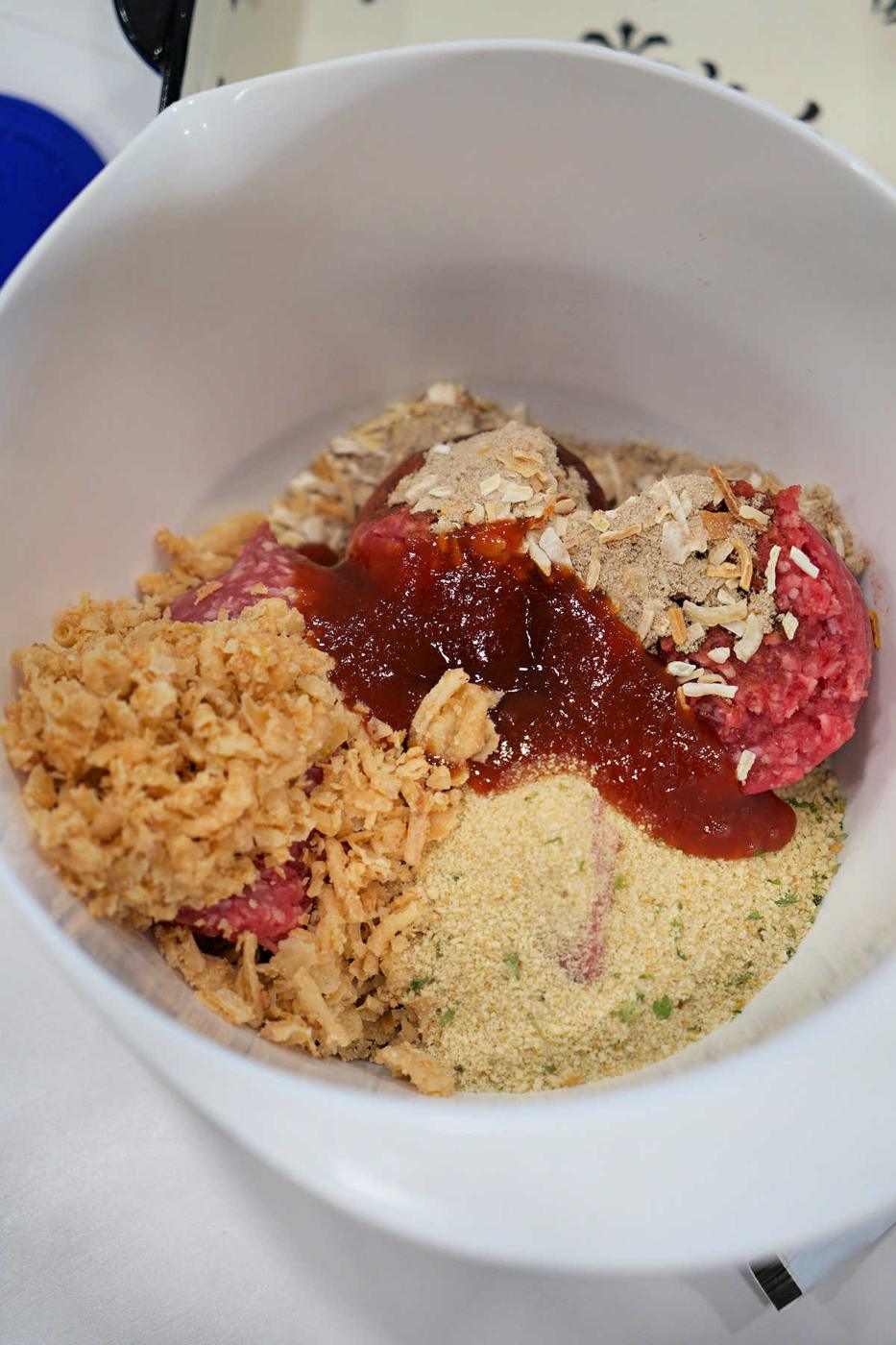 Unmixed meatloaf ingredients in a bowl, including ground beef, breadcrumbs, crushed chips, and sauce—perfect for starting your favorite BBQ meatloaf recipe.