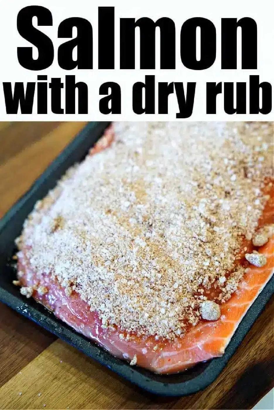Raw salmon fillet in a pan covered with a dry seasoning rub, ready to become the best baked salmon, on a wooden surface.