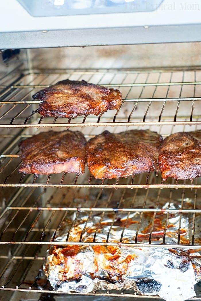 Smoked pork steaks and pork chops roast in electric smoker