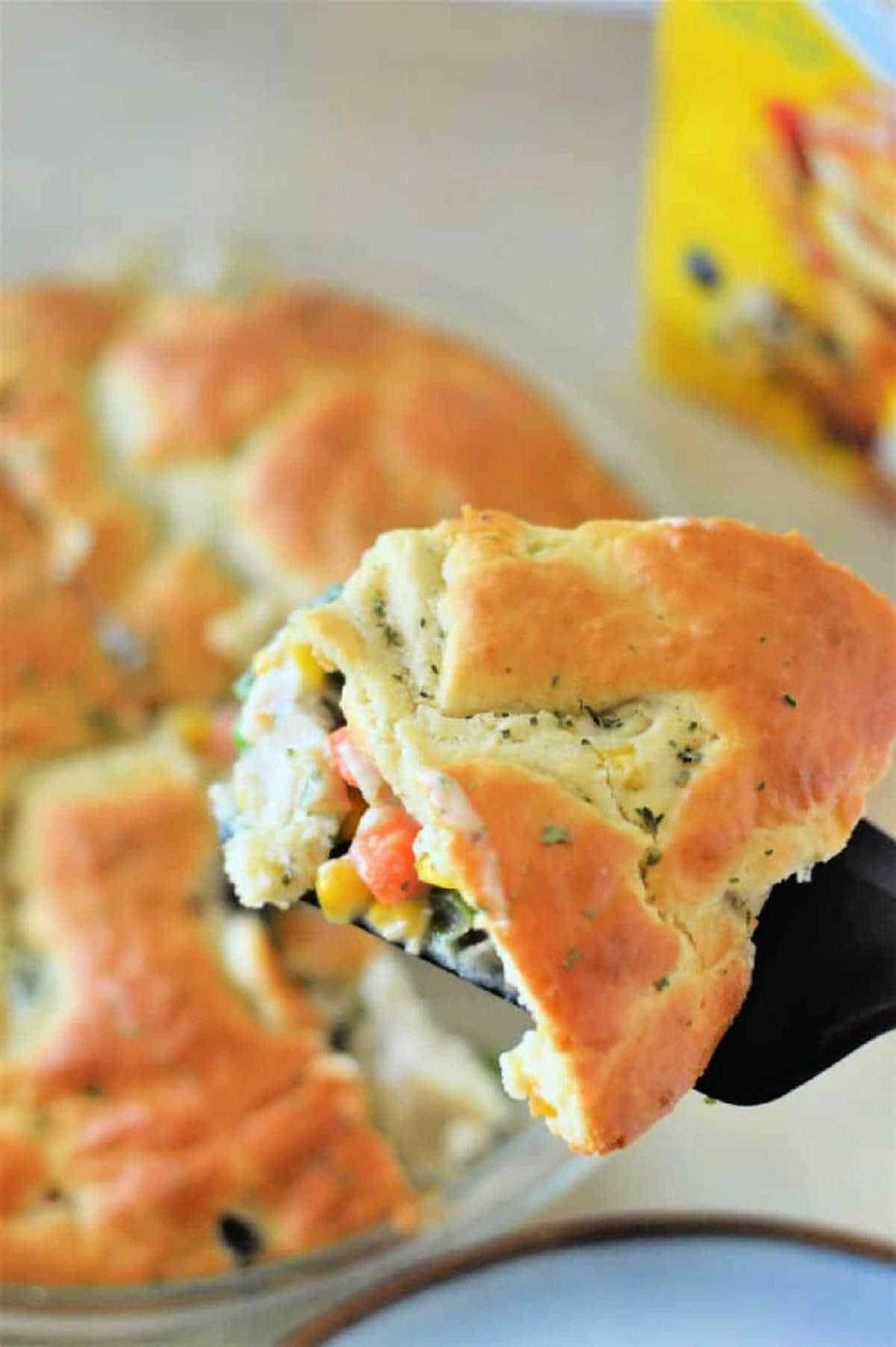 A slice of Bisquick Pot Pie with vegetables and a golden crust rests on a spatula, ready to delight your taste buds.