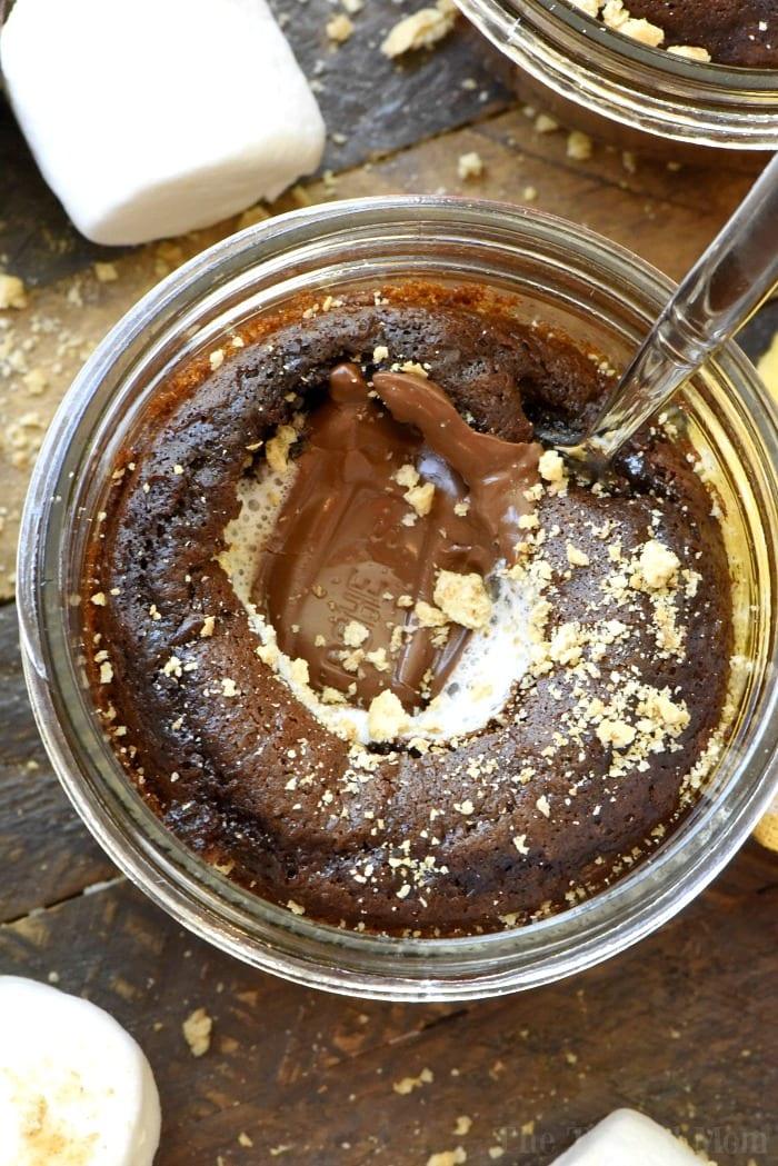 Chocolate cake in a jar with a melted center, topped with crumbs, and a spoon digging in—this dessert is the perfect example of how boxed cake mix recipes can be elevated to something irresistibly decadent. Fluffy marshmallows nearby add a playful touch.