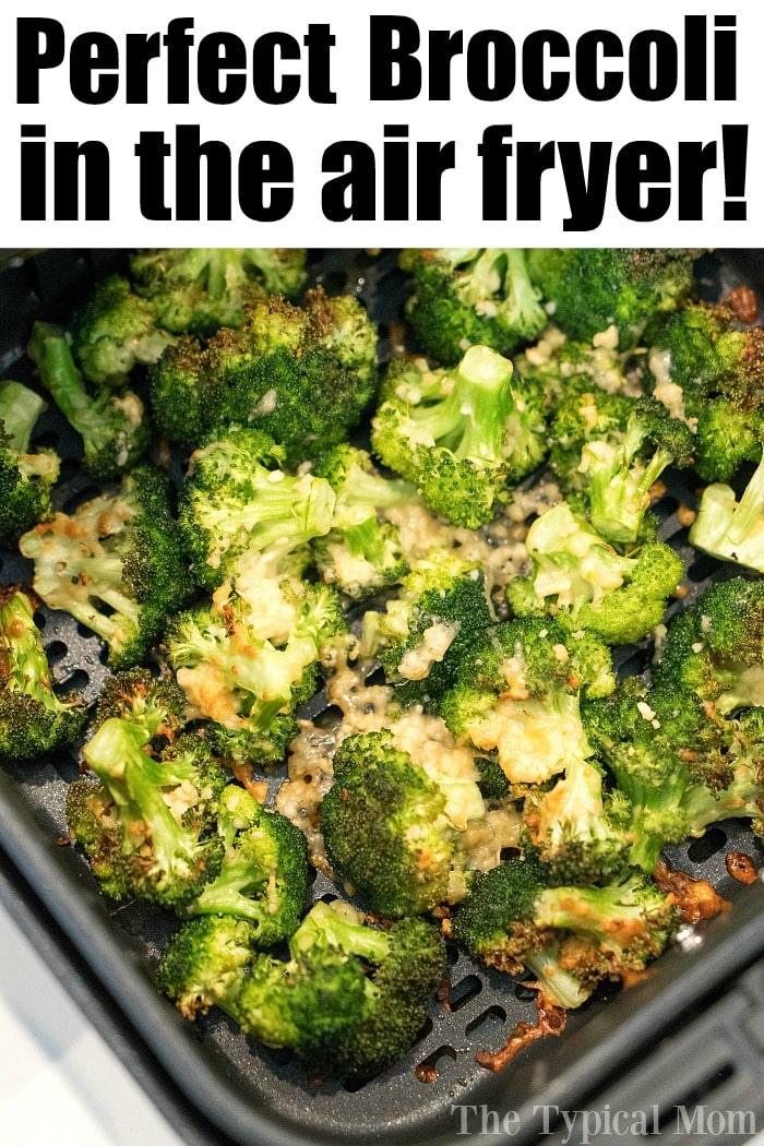 Air fryer basket filled with crispy broccoli in air fryer florets, perfectly cooked and topped with melted cheese.