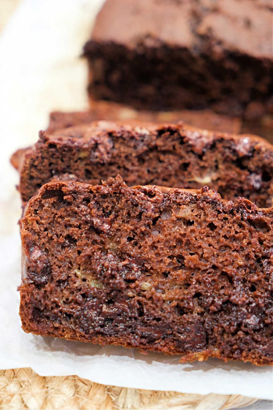 Close-up of thick, moist slices of chocolate banana bread made with cake mix on parchment paper.