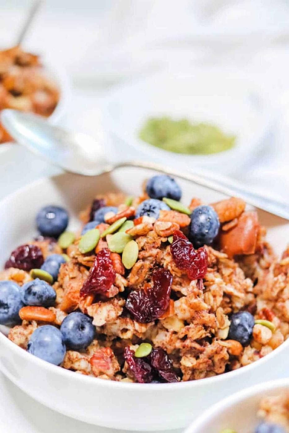 Bowl of cinnamon oatmeal baked to perfection, topped with blueberries, dried cranberries, pecans, and pumpkin seeds.
