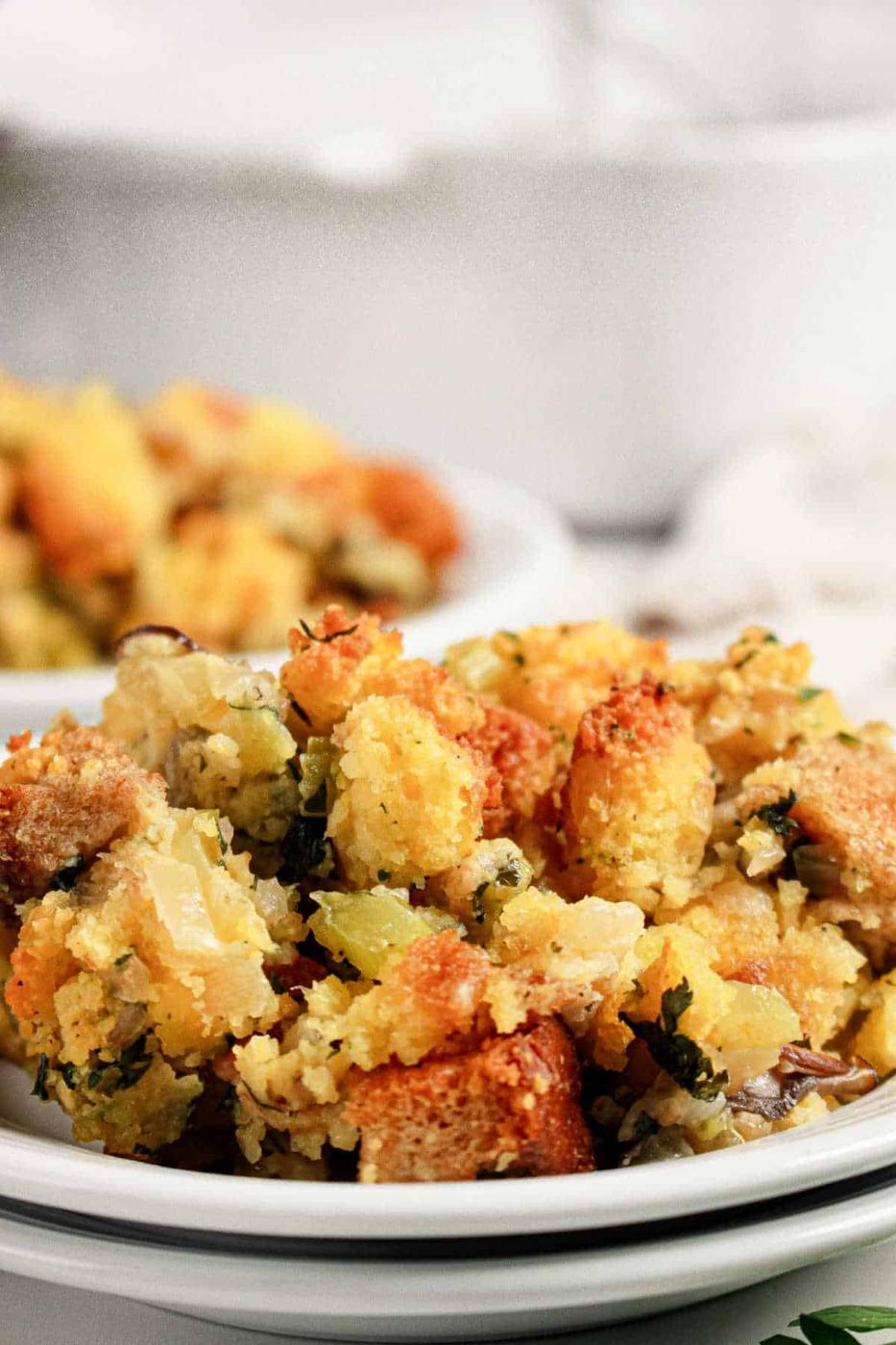 A plate of Jiffy cornbread stuffing with vegetables, served in a close-up view.