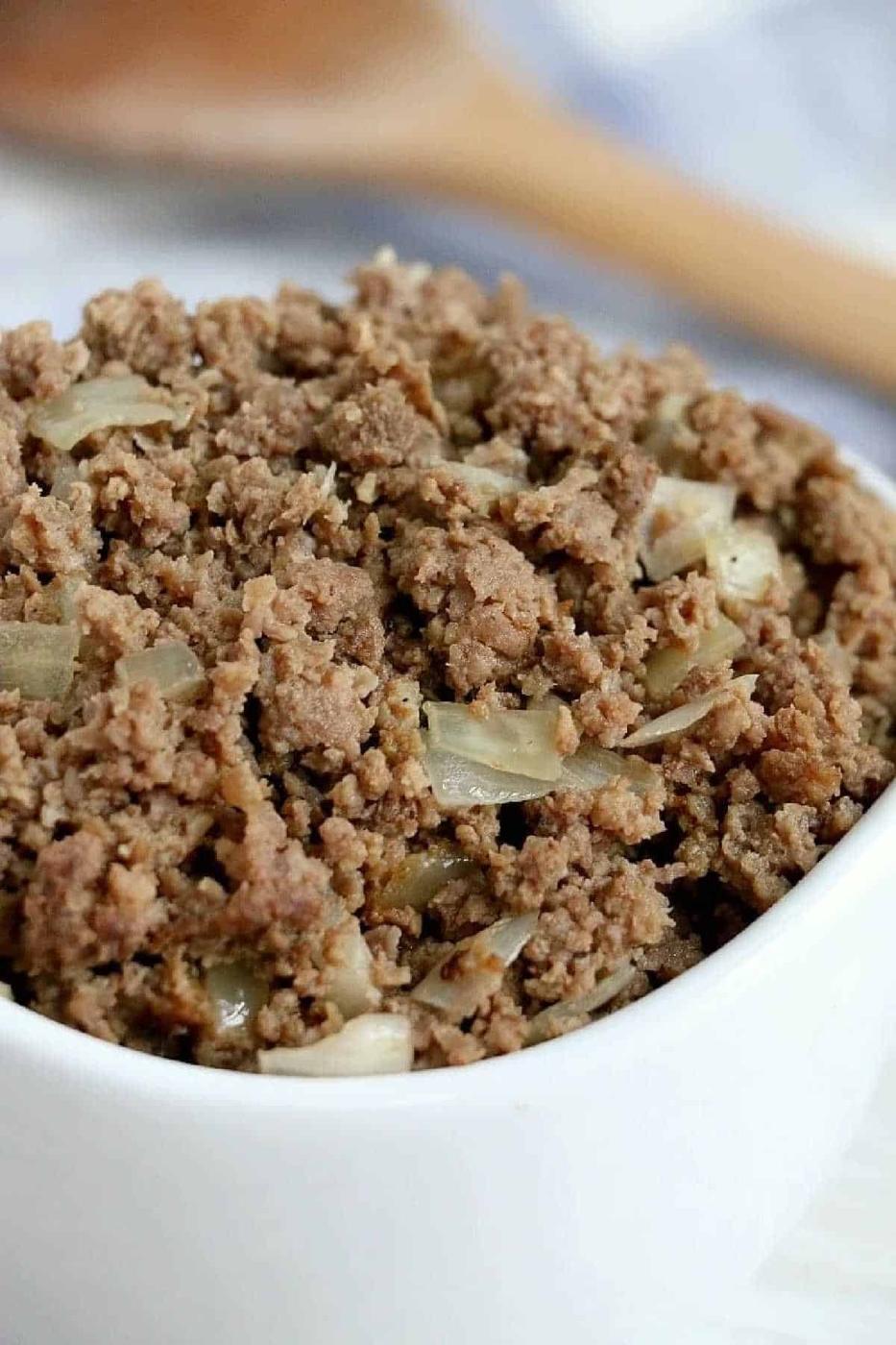 A bowl filled with crockpot ground beef and diced onions.