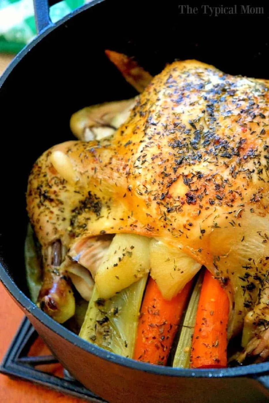 Dutch oven whole chicken, roasted with herbs and stuffed with carrots and celery for a flavorful, tender meal.