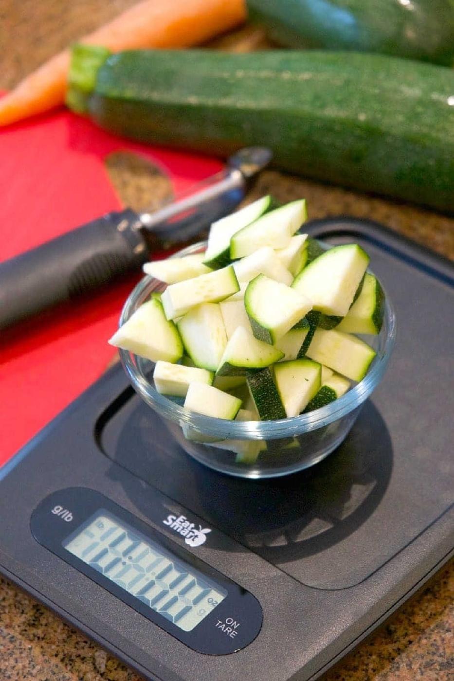A bowl of chopped zucchini on a scale, ready to be added to an easy Instant Pot minestrone soup.