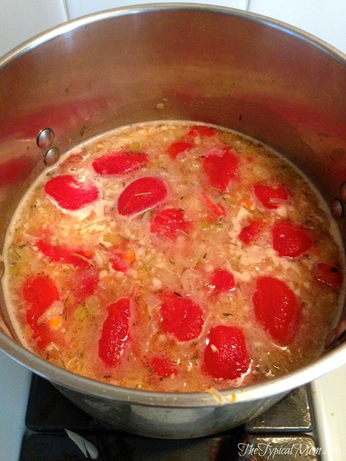 A pot of easy tomato bisque with chunks of tomatoes and spices simmers gently on the stove, promising a comforting meal.