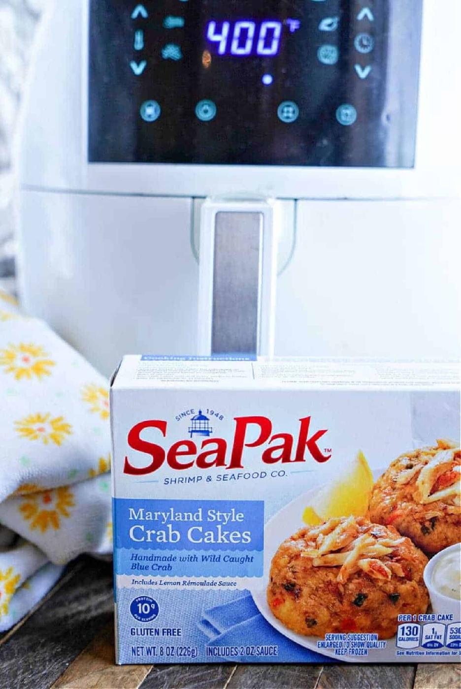 A box of SeaPak Maryland Style Frozen Crab Cakes sits in front of an air fryer displaying a 400°F temperature, ready for delicious results with the Frozen Crab Cakes in Air Fryer method.
