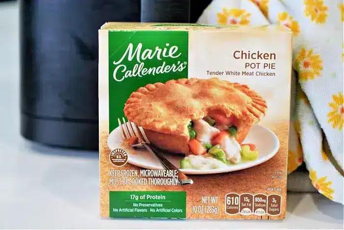 A Marie Callender's Chicken Pot Pie box is shown in the image, perfect for a quick meal in an air fryer. The packaging highlights tender white meat chicken, 17g of protein, and no preservatives or artificial flavors, while offering a clear view of the product's nutritional information.