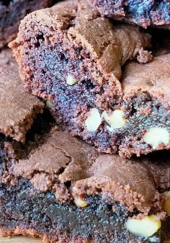Close-up of stacked chocolate brownies made with homemade brownie mix, with visible walnut pieces embedded in the layers, showcasing a dense and fudgy texture.