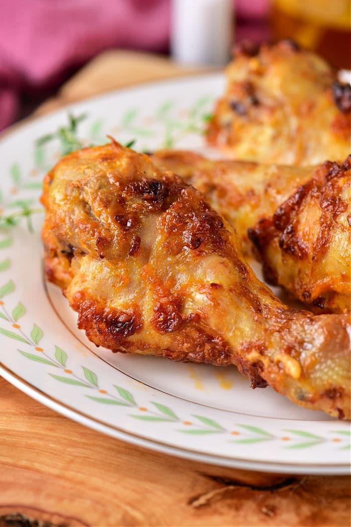 Close-up of a plate with crispy boiled chicken drumsticks garnished with herbs, a perfect follow-up after mastering how long to boil chicken legs for juicy tenderness.