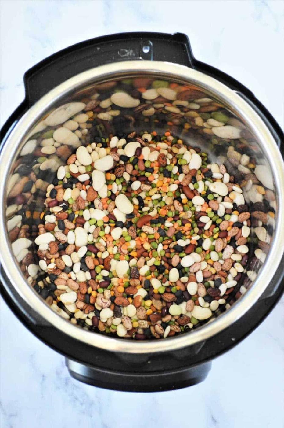 Instant Pot 15 bean soup sits invitingly on a marble countertop, showcasing its hearty mix of flavors and rich textures.