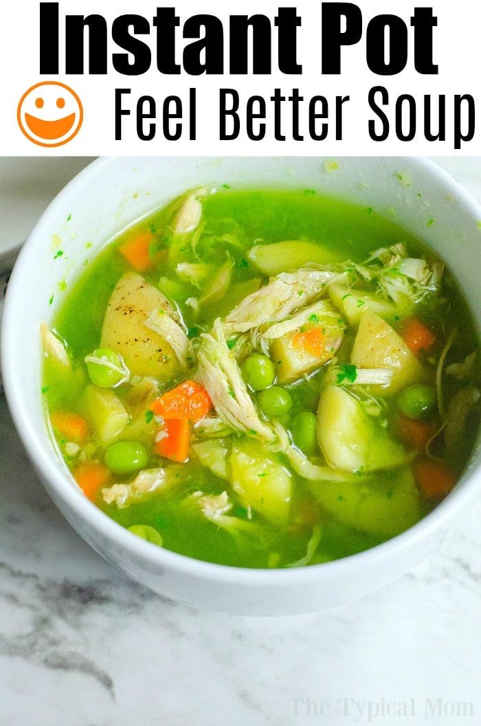 A bowl of Instant Pot Feel Better Soup with chicken, carrots, peas, and potatoes rests on a marble surface.