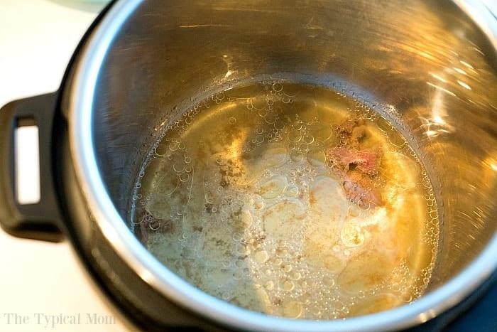 Cooking frozen ground beef in an Instant Pot with broth and seasonings visible, alongside frozen ground beef, creates a flavorful meal with ease.