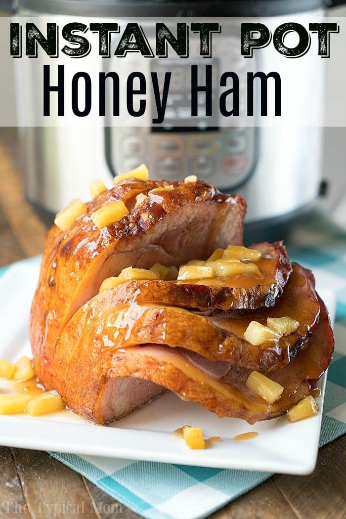 Sliced honey-glazed ham topped with diced pineapple on a white plate. An Instant Pot is visible in the background, highlighting the delicious creation of "Instant Pot Ham.