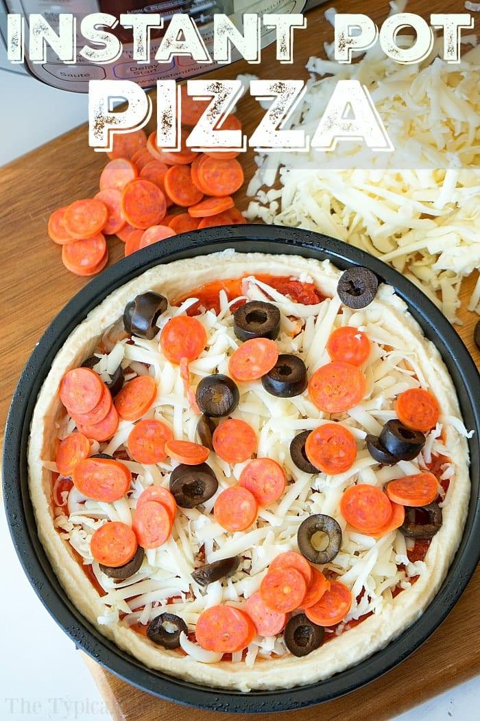Uncooked instant pot pizza in a pan with cheese, pepperoni, and olives, next to shredded cheese and sliced pepperoni.