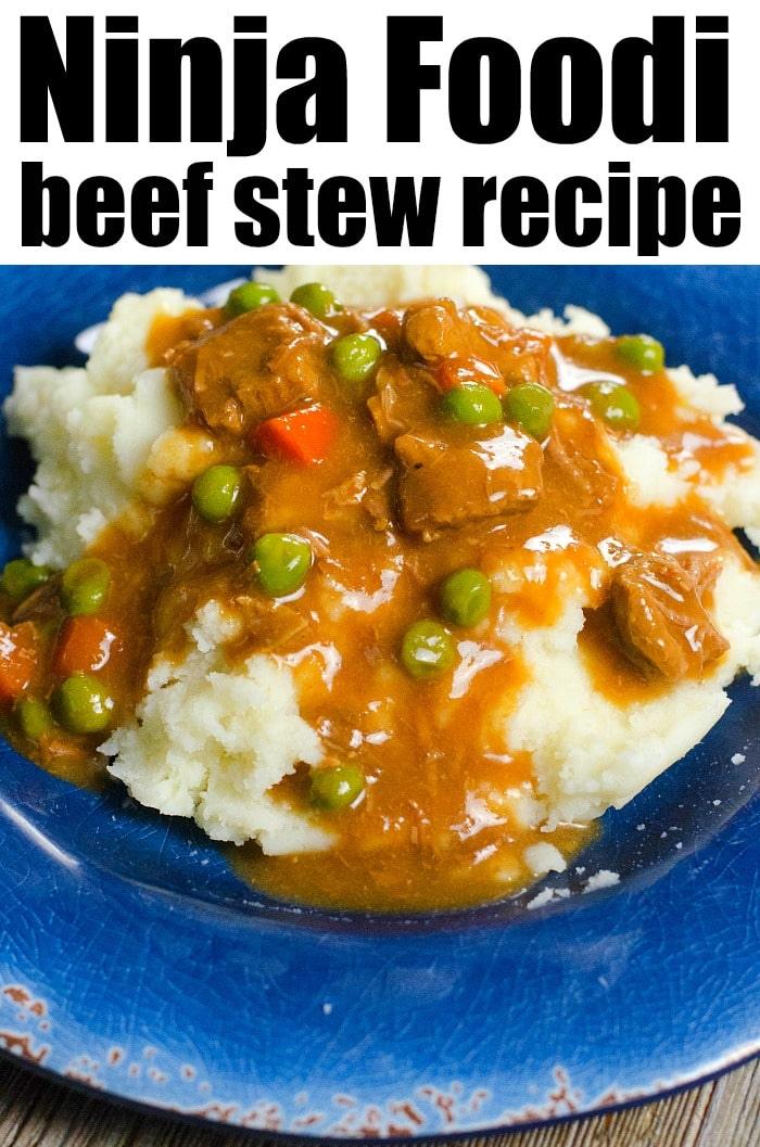 A plate of Ninja Foodi beef stew brimming with peas and carrots sits invitingly over mashed potatoes on a blue plate.