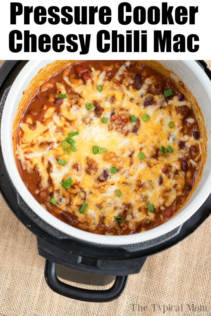 A top view of a ninja foodi reveals a delicious batch of cheesy chili mac, perfectly garnished with chopped green onions.