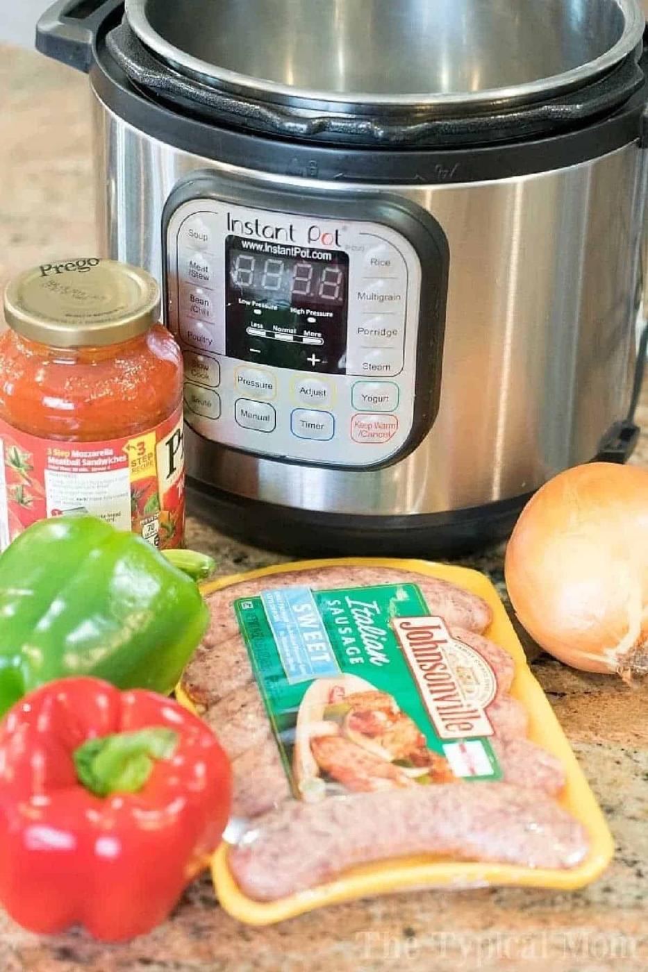Pressure cooker sausage with marinara sauce, onion, green bell pepper, and red bell pepper sits on a kitchen counter for a quick and delicious meal.