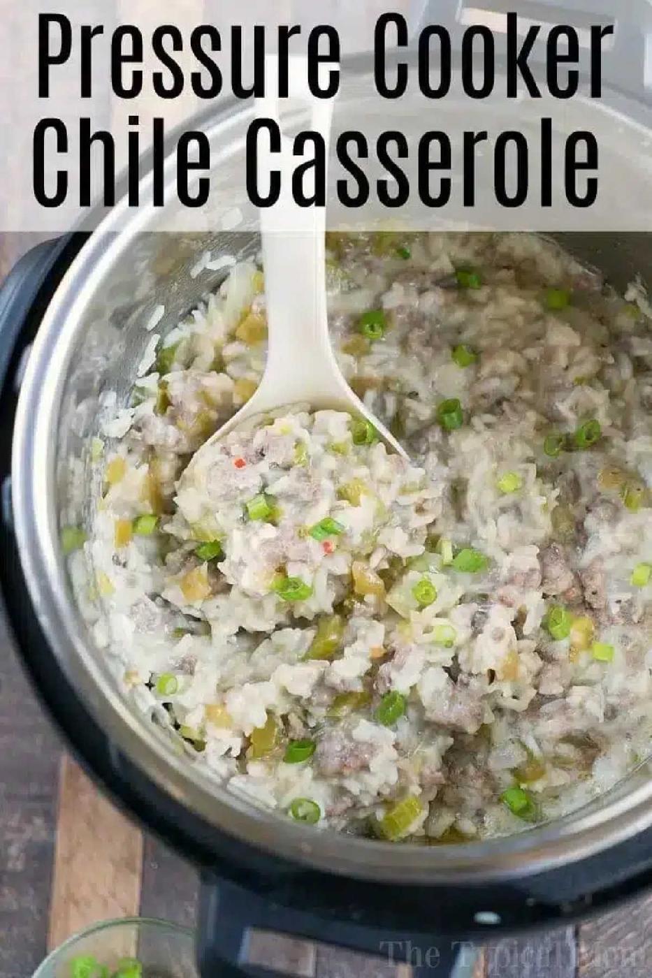 A spoon scoops instant pot sausage rice casserole with ground meat and chile from a pressure cooker, topped with chopped green onions.