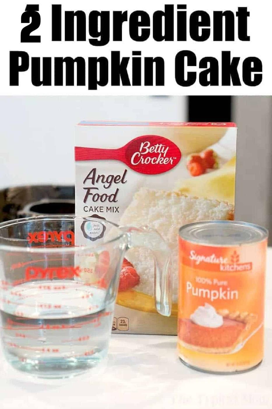 Box of angel food cake mix, a can of pumpkin, and a measuring cup of water sit on the counter—ingredients ready to make a delicious pumpkin angel food cake.