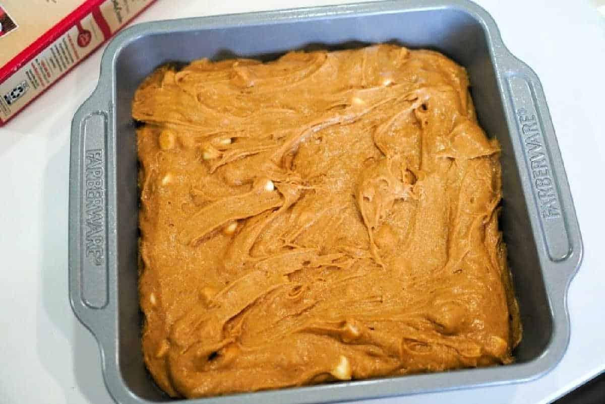 Baking pan filled with unbaked pumpkin blondies batter, ready to go into the oven.