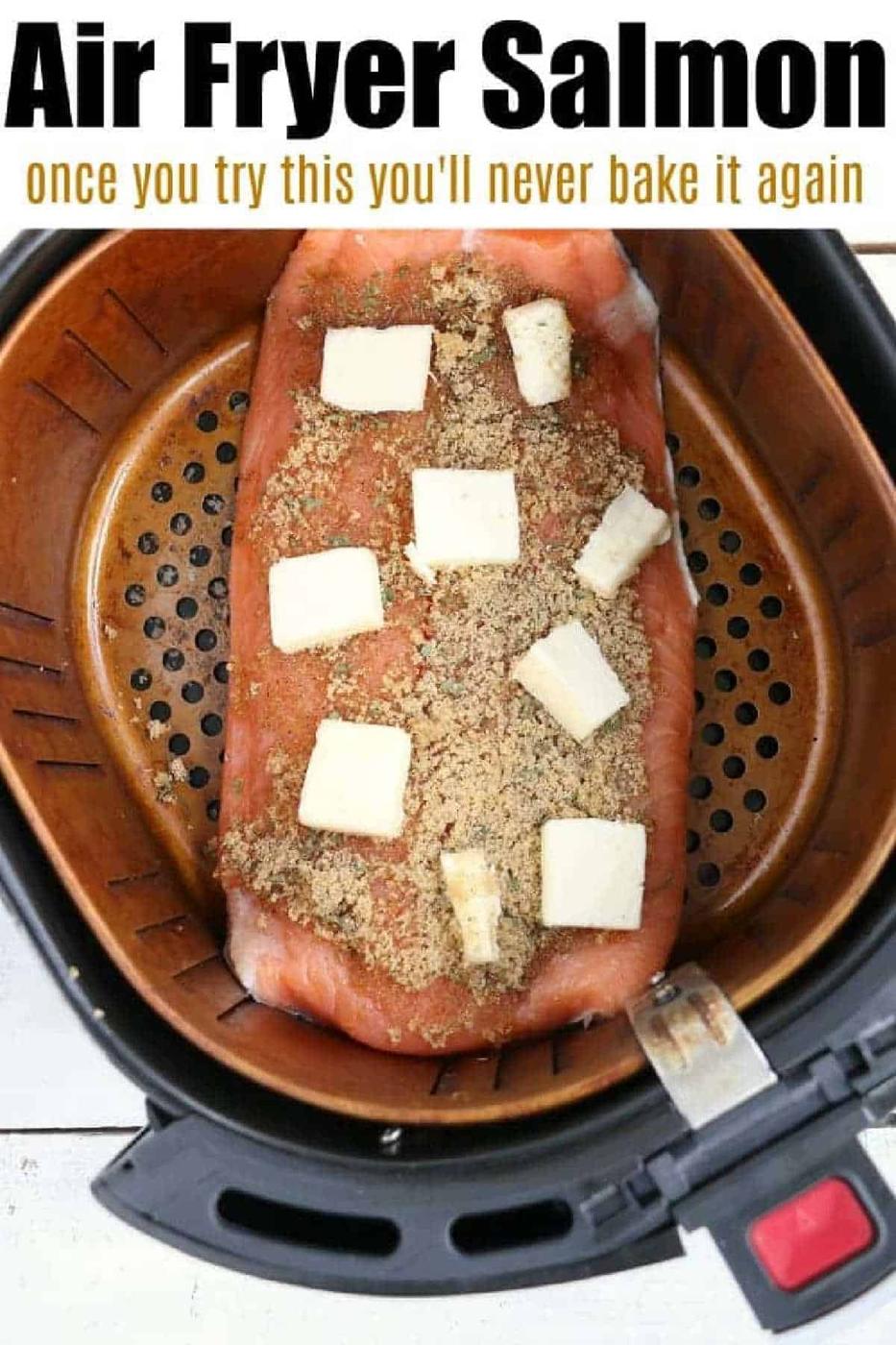 Salmon filet with seasoning and butter cubes in an air fryer basket, ready to be cooked—perfect for making delicious salmon in the air fryer.