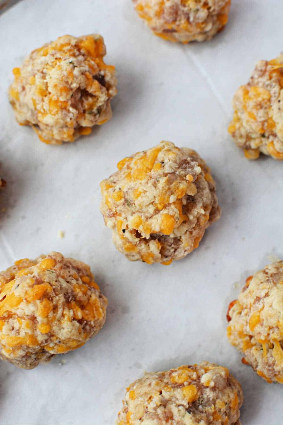 Close-up of several cheesy sausage balls made with Red Lobster Biscuit Mix on parchment paper.