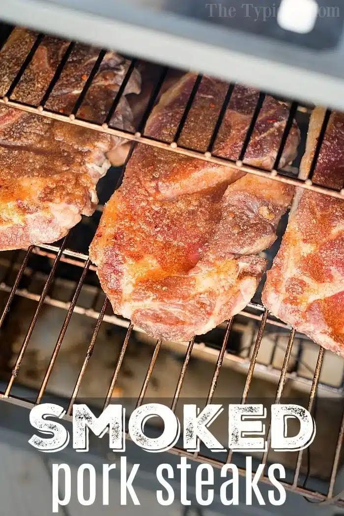 Four large pork steaks, perfectly seasoned, sizzle on a wire rack inside the smoker. The caption at the bottom proudly announces: SMOKED pork steaks.