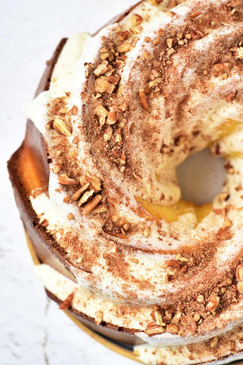 A delicious bundt cake topped with white icing, crushed nuts, and cocoa powder, this creation offers a delightful twist on the classic Sock it to me cake recipe with cake mix. Seen from above, its an irresistible treat for any dessert lover.