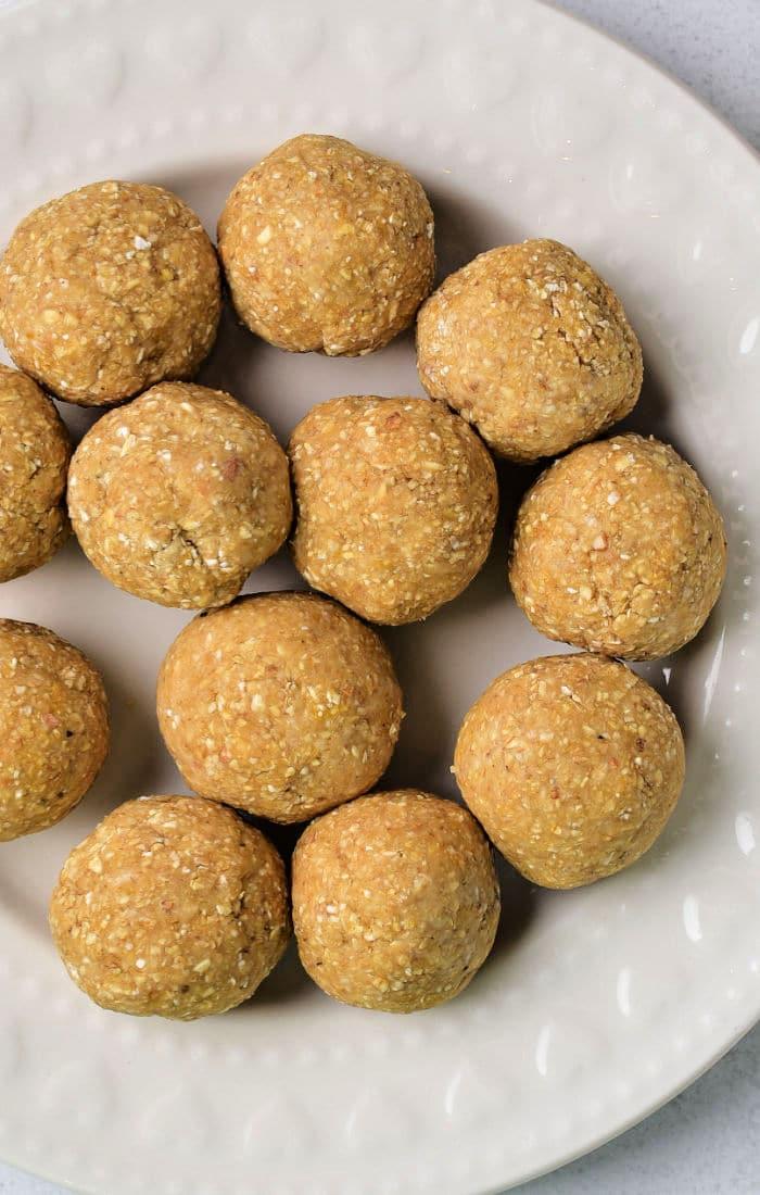A cream-colored plate displaying round matzo balls homemade