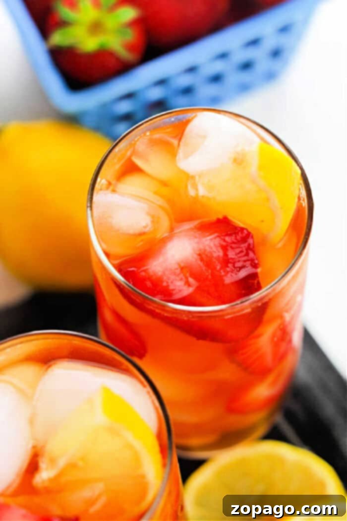 Sweet Berry Hibiscus Brew 2 Hibiscus Sweet Tea: A refreshing, ruby-red beverage garnished with lemon slices and mint leaves, perfect for summer.