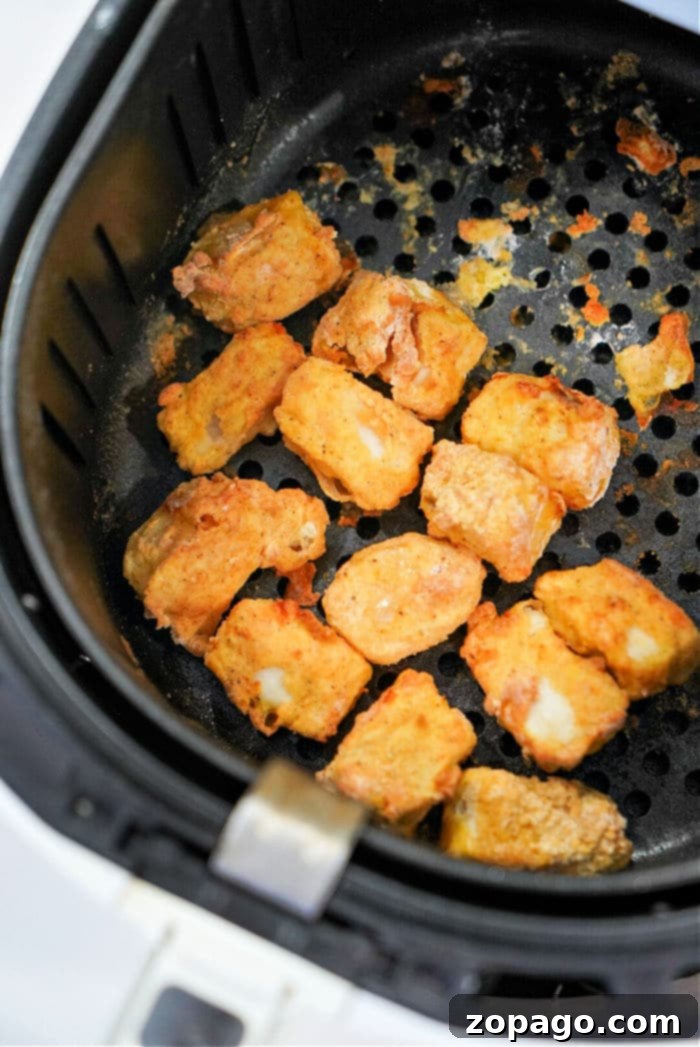 Wholesome Air Fryer Creations 7 Air fryer basket with perfectly crisped fish nuggets, ready to eat.