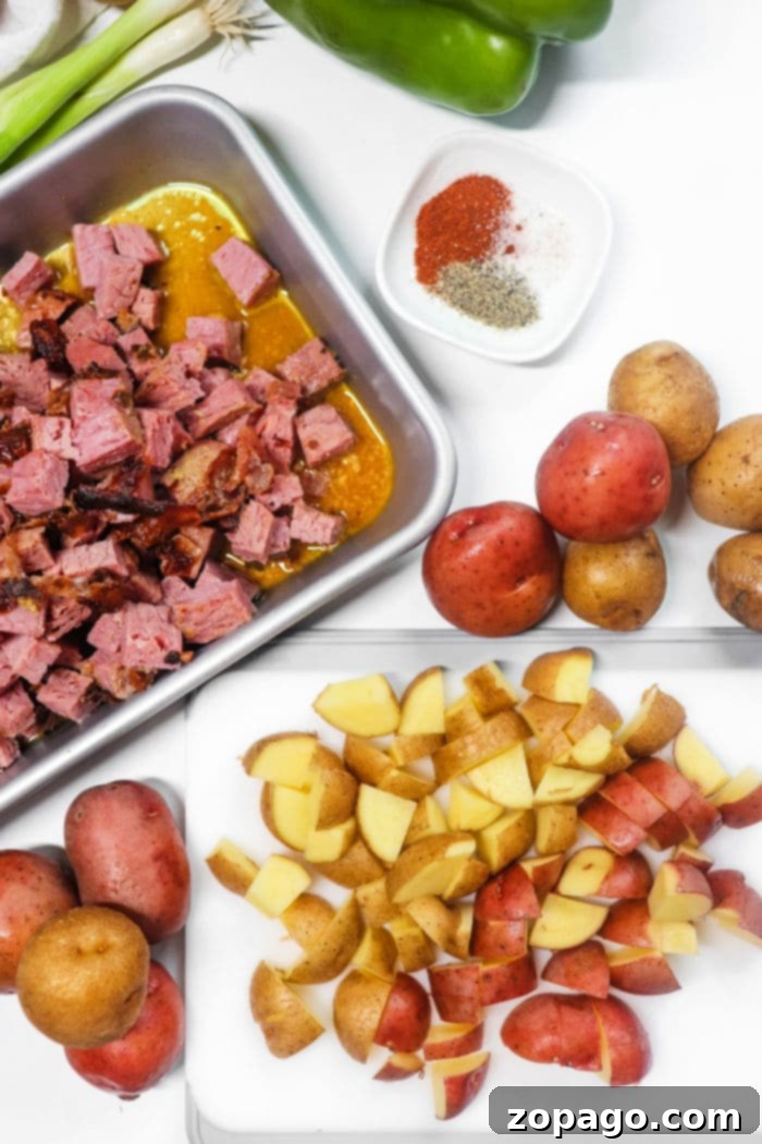 Second Life Corned Beef Recipes 3 Chopped corned beef meat in a tray, diced potatoes on a cutting board, with spices and vegetables around—perfect for creating an Air Fryer Corned Beef Hash with tender red potatoes.