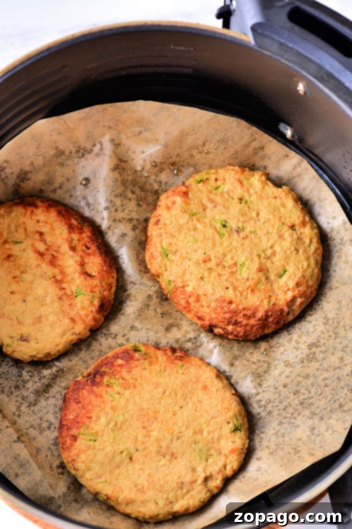 Juicy Air Fryer Turkey Patties 5 A plate of golden-brown leftover turkey patties with a side of dipping sauce.