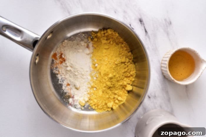 Crafting Your Perfect Hot Dog Mustard 3 Close-up of creamy homemade mustard sauce in a bowl with a spoon, highlighting its smooth texture.