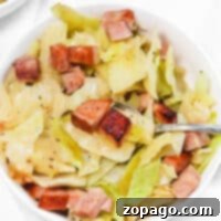 A bowl of savory cabbage and ham stew, perfectly seasoned and ready to enjoy with a spoon.