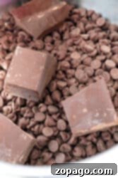 Chocolate chips and chunks of chocolate bar in a bowl, perfect for making fudge with peanut butter and condensed milk, ready for melting or mixing.