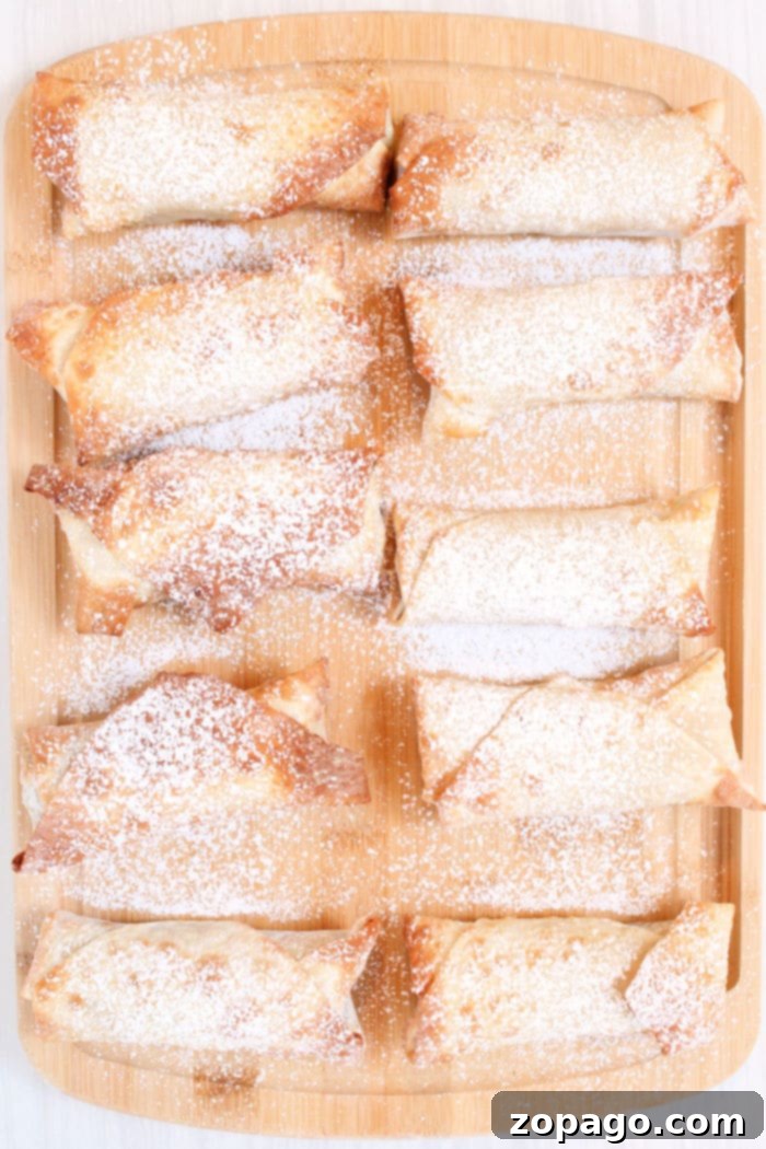 Crispy Air Fryer Apple Pie Egg Rolls 7 Hot and ready apple pie egg rolls from the air fryer, glistening with a golden crust.