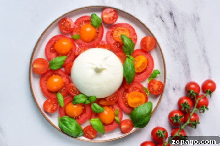 Burrata Caprese Nasıl Yapılır? 4 A vibrant Burrata Caprese pasta dish, showcasing the creamy burrata melted into the al dente noodles with fresh tomatoes and basil.