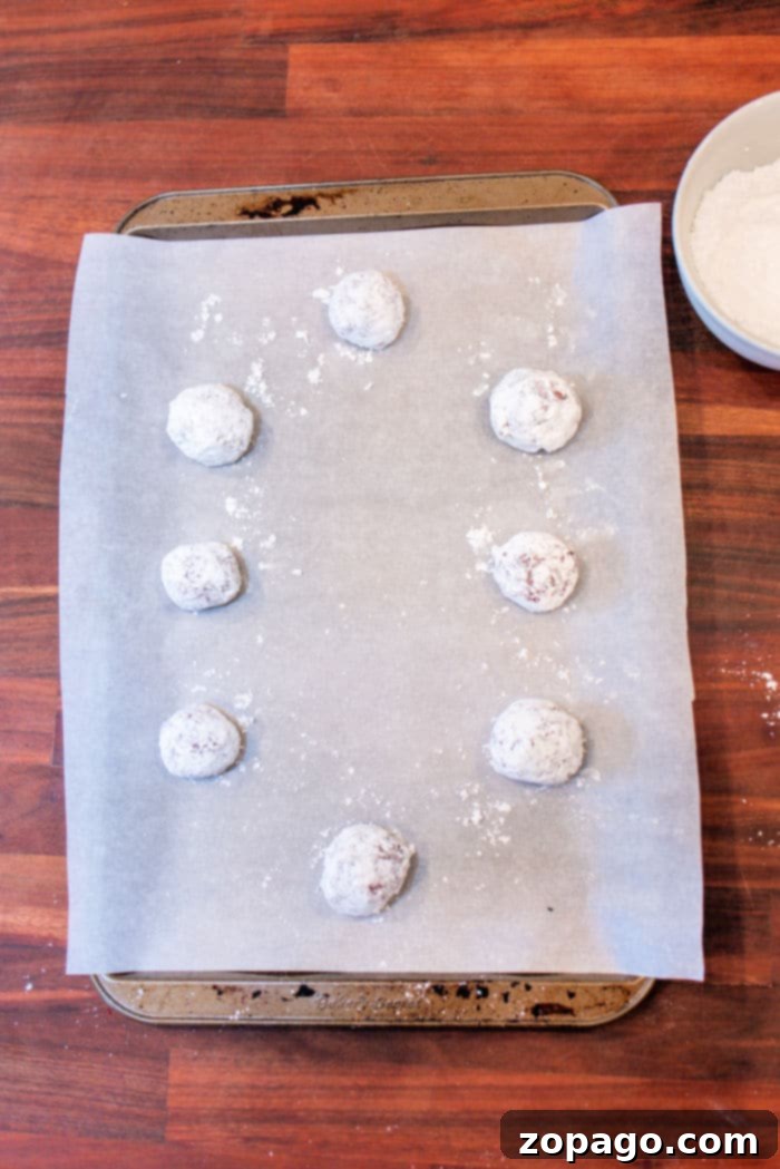Red Velvet Crinkle Cookies Cake Mix 4 Red Velvet Crinkle Cookies made from cake mix, these raw cookie dough balls are covered in powdered sugar and rest on a parchment-lined baking sheet.