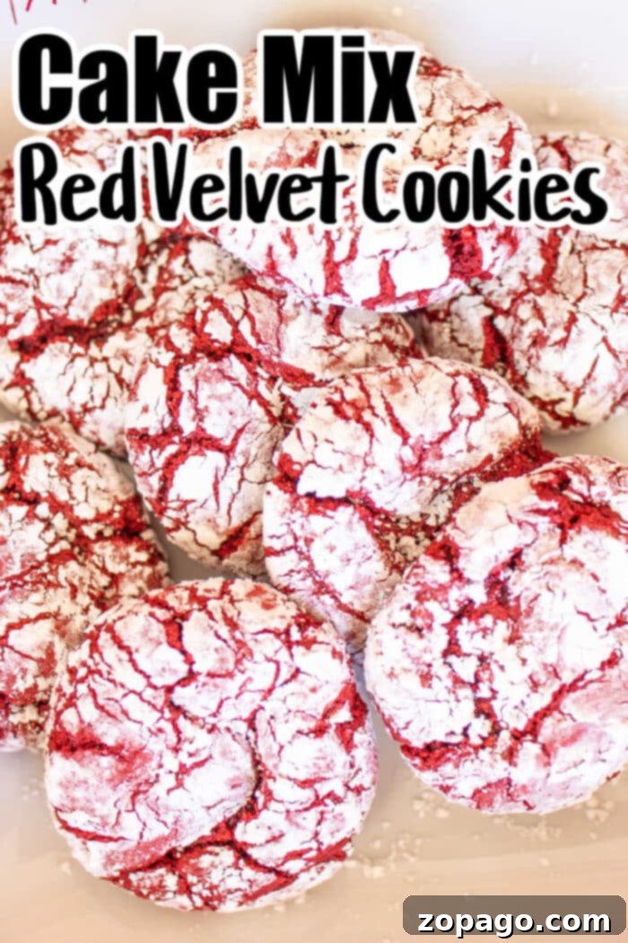 Red Velvet Crinkle Cookies Cake Mix 5 A pile of Red Velvet Crinkle Cookies coated in powdered sugar is pictured. The text at the top reads "Cake Mix Red Velvet Cookies." The cookies have a cracked appearance, with red velvet showing through the white powdered sugar.