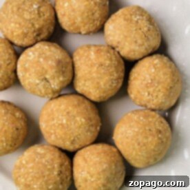 A cream-colored plate displaying round matzo balls homemade